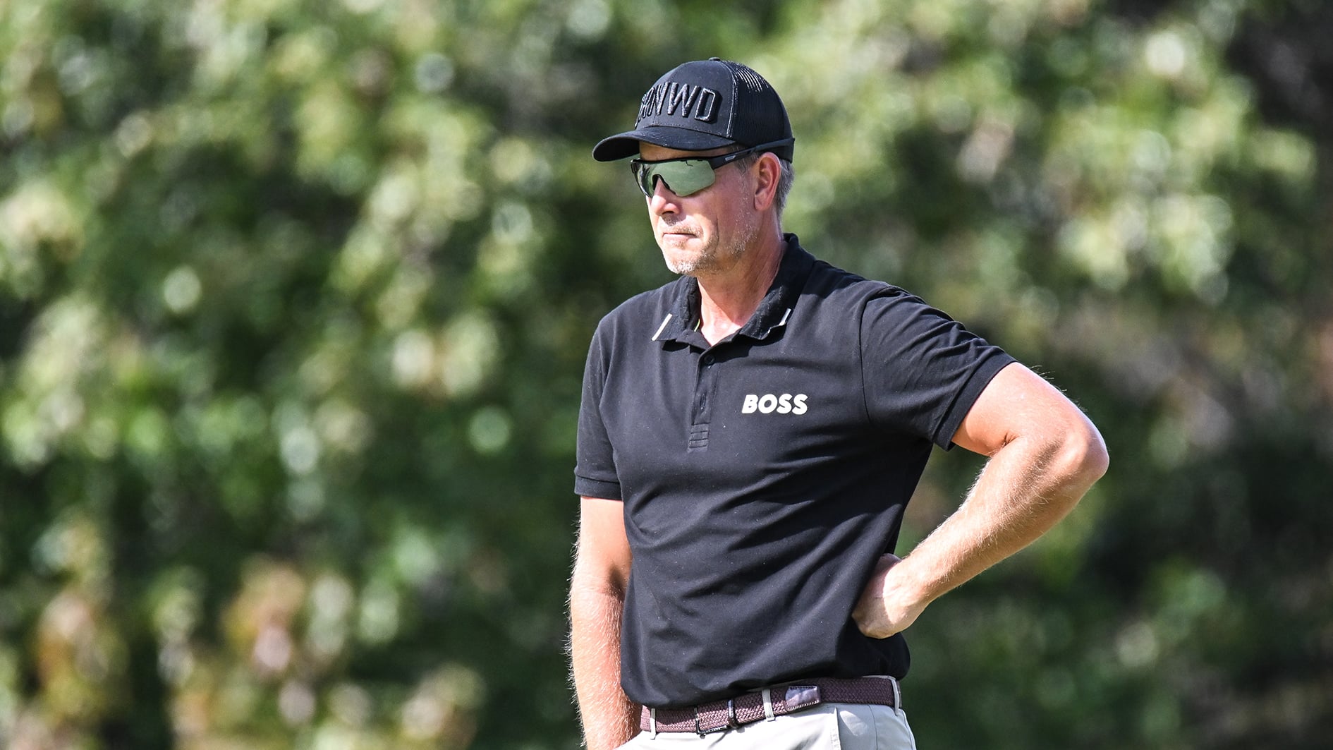 golfspelaren henrik stenson i svarta golfkläder på golfbana i USA med många lövträd