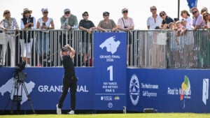 golfspelare slår med driver på golftävling med publik och läktare