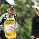 glad caddie och spelare på golfbana under golftävling