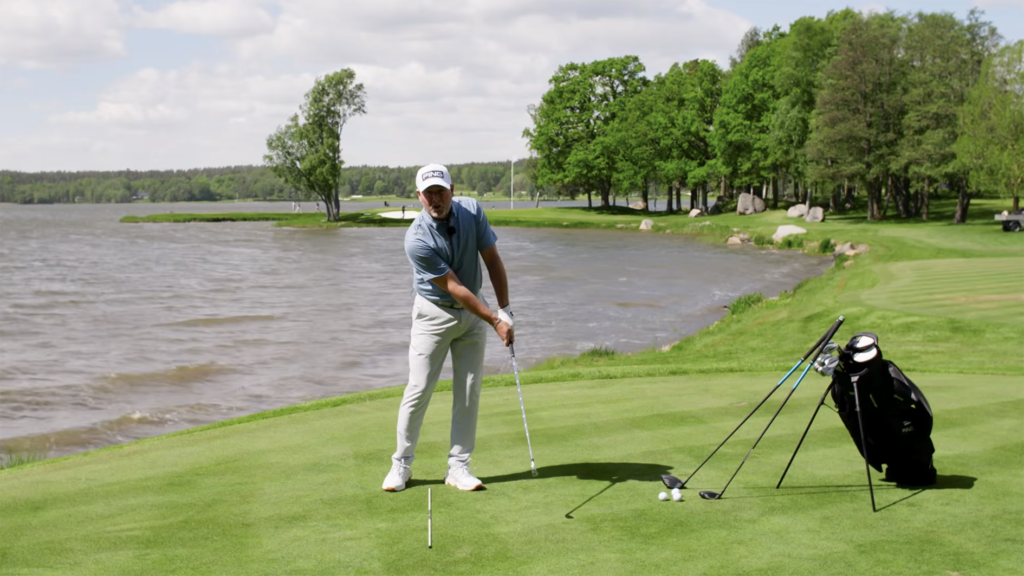 golftränare visar golfsving på golfbana vid sjö